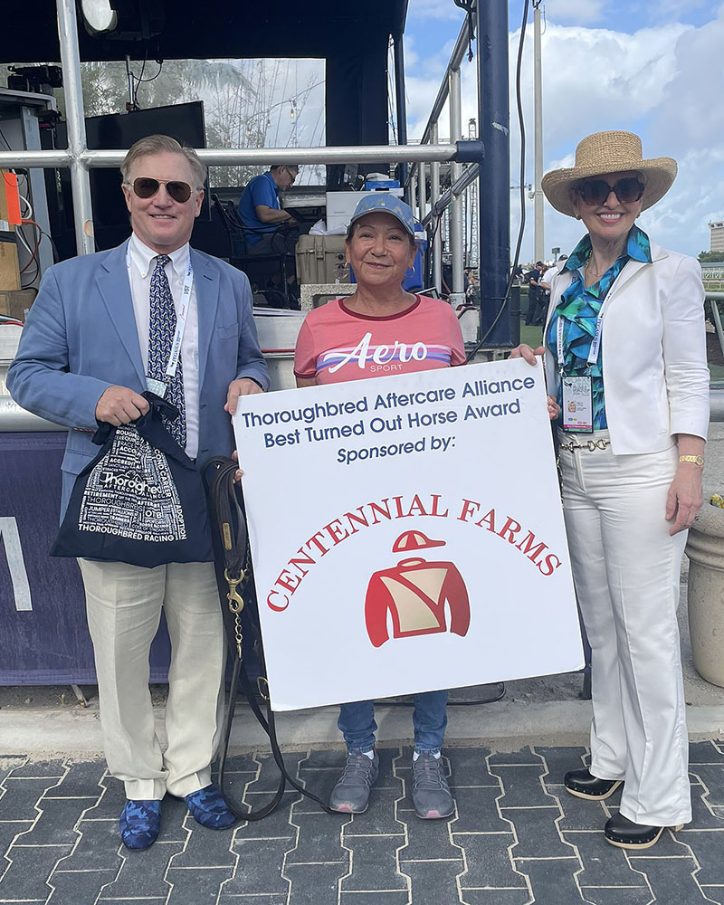 Don Little, Jr. and Holly Little present a Best Turned Out Horse Award to Angelica Paz of the Shug McGaughey barn. Paz is the groom of Dreams of Tomorrow, who ran in the seventh race on Pegasus World Cup Day at Gulfstream Park.